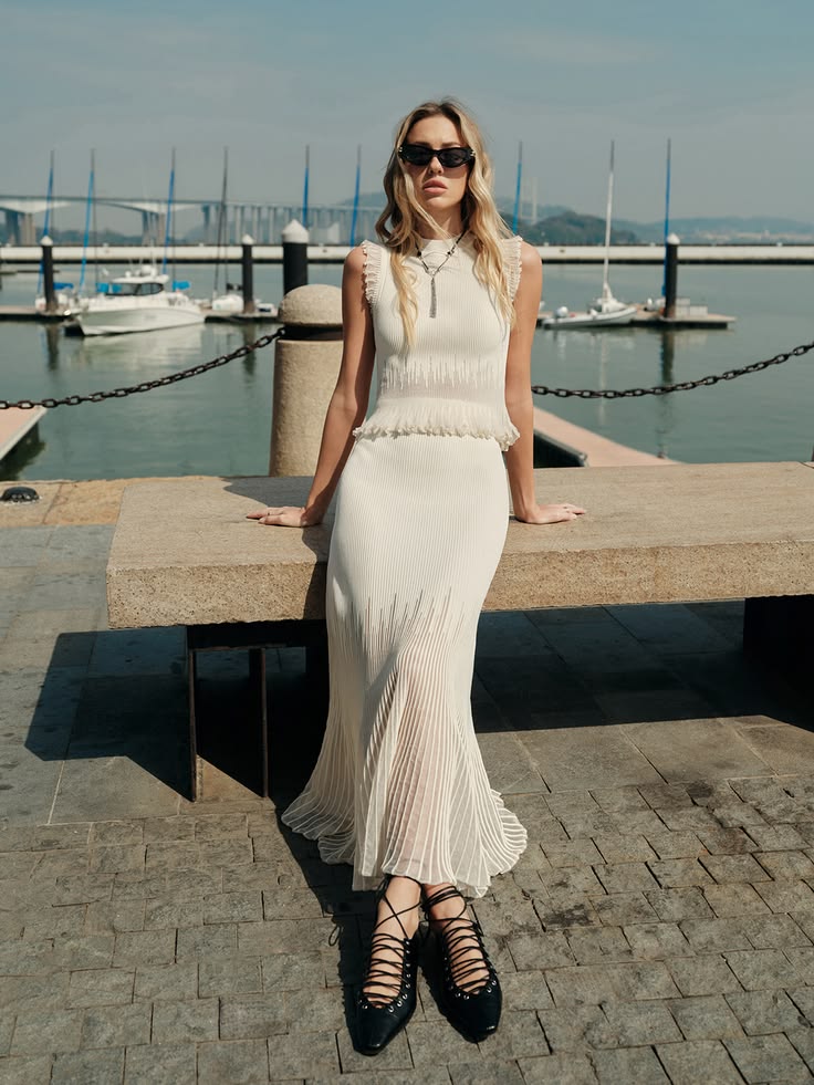 Woman wearing an elegant white dress by the marina